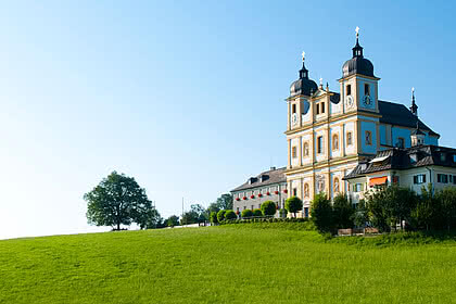 Die Wallfahrtskirche Maria Plain auf einer grünen Wiese