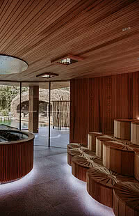 Innenausstattung mit vielen Holzelementen und großen Glasfronten der Teichsauna im Hang SPA im Genussdorf Gmachl in Bergheim bei Salzburg