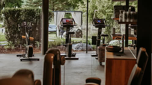 [Translate to English:] Der Fitnessraum im Hotel Gmachl mit Aussicht in den Garten