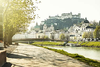 Promenadenweg entlang der Salzach mit Blick auf die Festung Hohensalzburg und die Altstadt