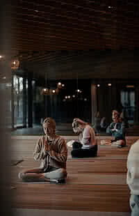 Frauen meditieren in einem stilvollen Yoga-Raum im Genussdorf Gmachl in Bergheim – perfekte Auszeit für einen Yoga Urlaub in Salzburg.